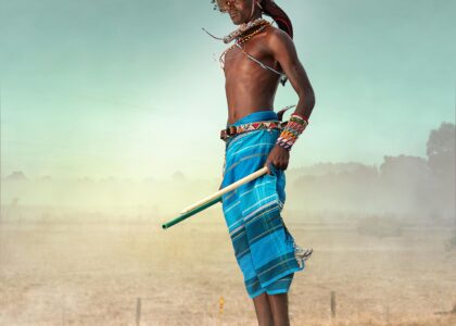 A Maasai warrior in traditional attire jumps high, showcasing cultural dance in Kenya.